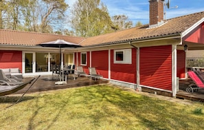 A red house with a patio, a sliding glass door, and a small window.