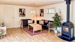 Een gezellige woonkamer met een bank, salontafel en een open haard.
