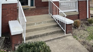 A two-story house with a covered porch, a front door, and a mailbox.