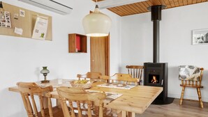 A cozy dining area with wooden furniture, a central table, and a wood-burning stove. - Awesome apartment in Hasle with WiFi (Hasle)