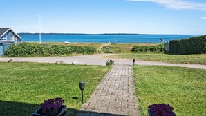 A pathway leading to a house with a view of the sea. - Lovely home in Fredericia with WiFi (Fredericia)