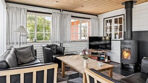 A cozy living room with a fireplace, leather furniture, and a flat-screen TV. - Lovely home in Fredericia with WiFi (Fredericia)