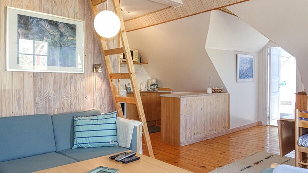 Ein gemütlicher Lofts-Wohnbereich mit Schlafgalerie, einer Küchenzeile und einem Essbereich.