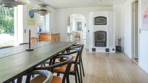 Un'ampia cucina con un lungo tavolo in legno, un forno integrato e una zona pranzo con sedie.