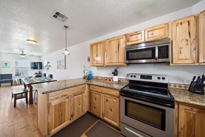 Enjoy cooking in this well-equipped kitchen with a central island, stove, and oven.