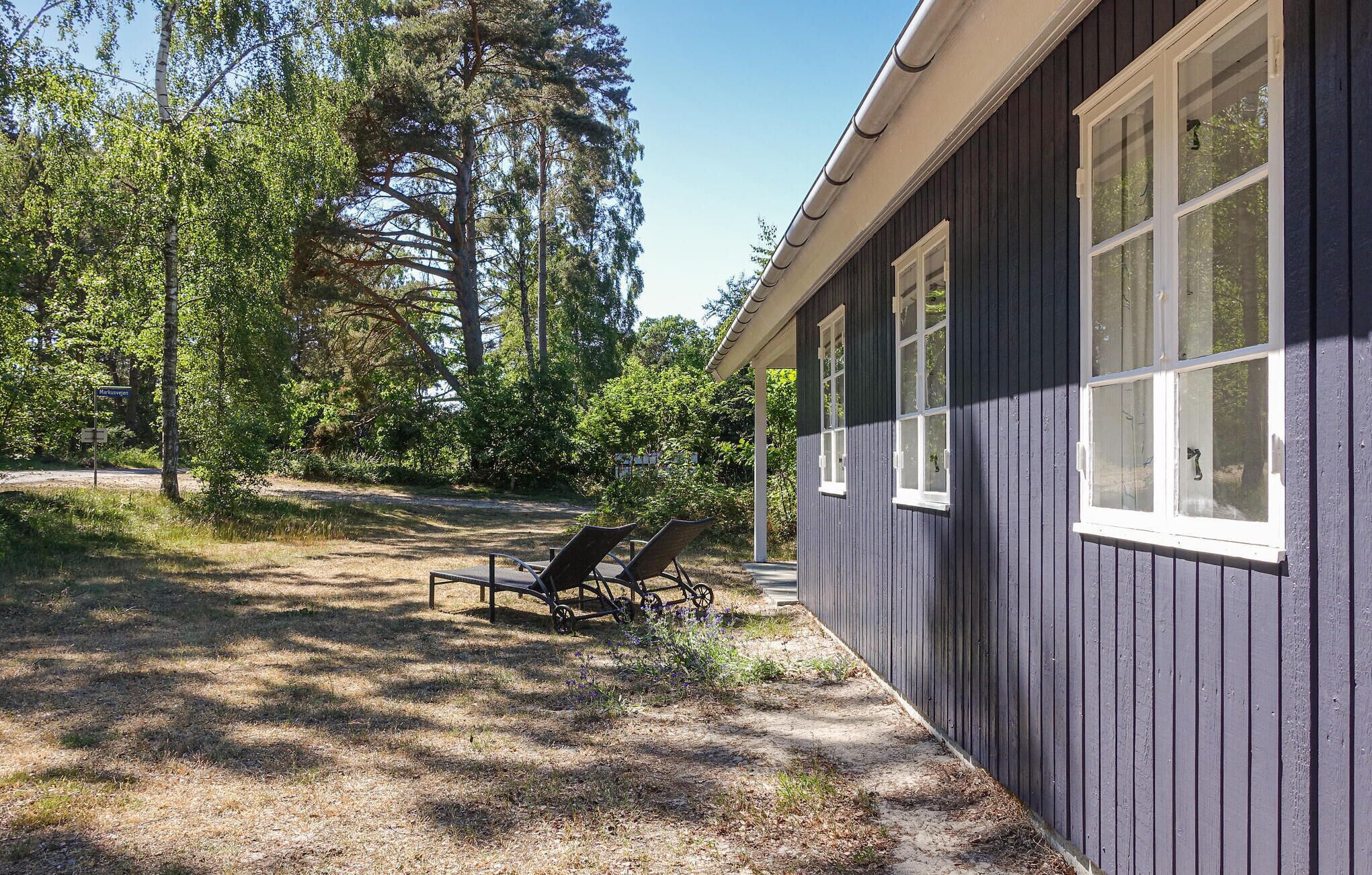 Ein Haus mit einer Veranda, zwei Fenstern und einem Stuhl davor.