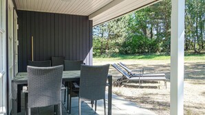 An outdoor patio with wicker furniture, a table, and two lounge chairs. - Stunning home in Aakirkeby with WiFi (Aakirkeby)