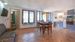 Un espacio habitable compacto con comedor, kitchenette y sofá.