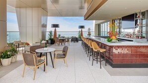 A rooftop bar with seating, a bar counter, and a view of the city. - Yaamava’ Resort & Casino at San Manuel (Highland)
