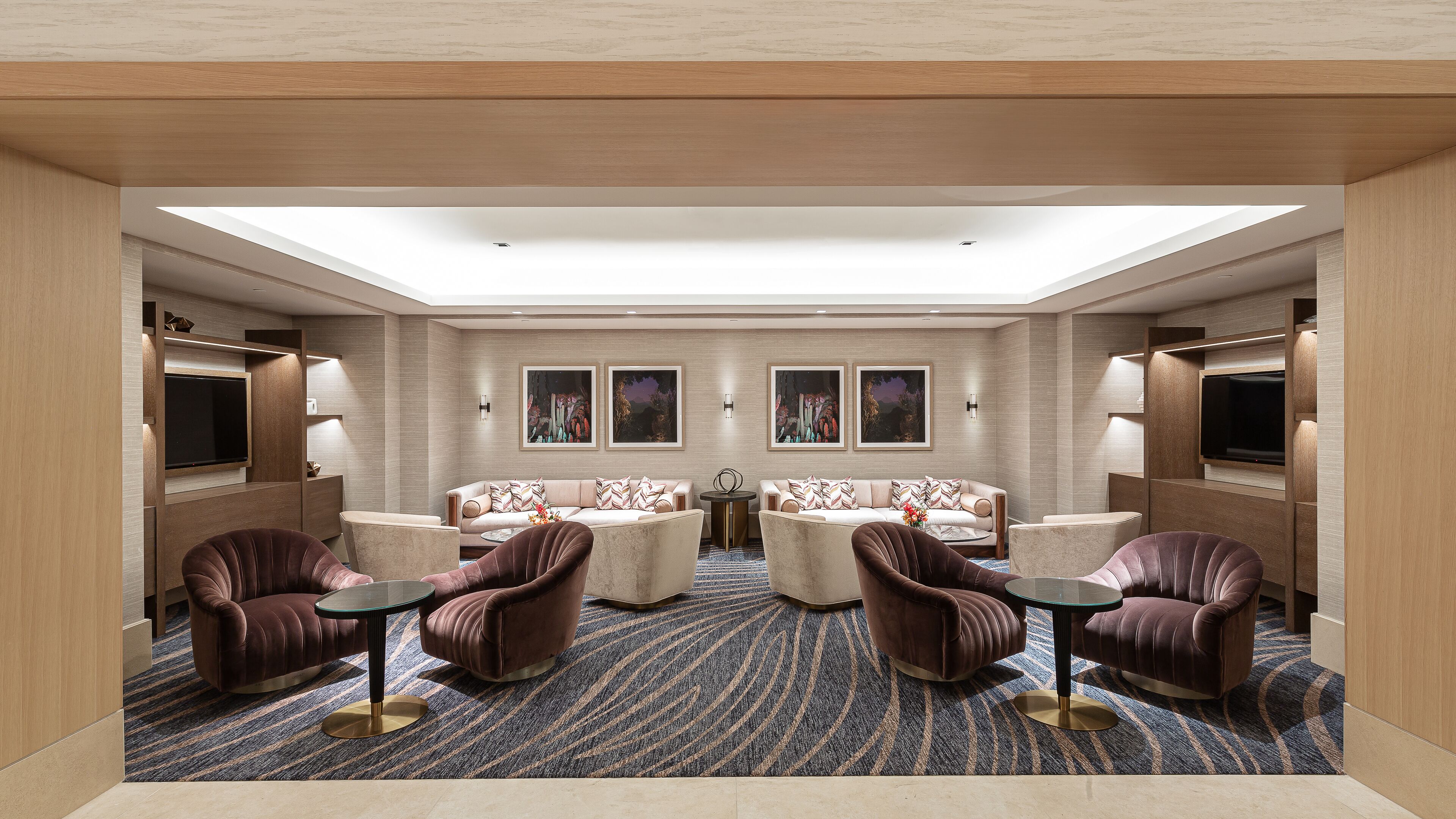 A spacious, well-lit lounge area with a high ceiling, comfortable seating, and artwork on the walls.