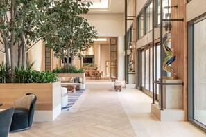 A spacious indoor area with a large tree, seating arrangements, and a modern design. - Yaamava’ Resort & Casino at San Manuel (Highland)