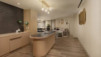 A modern kitchen with a central island, wooden cabinetry, and a dining area in the background.