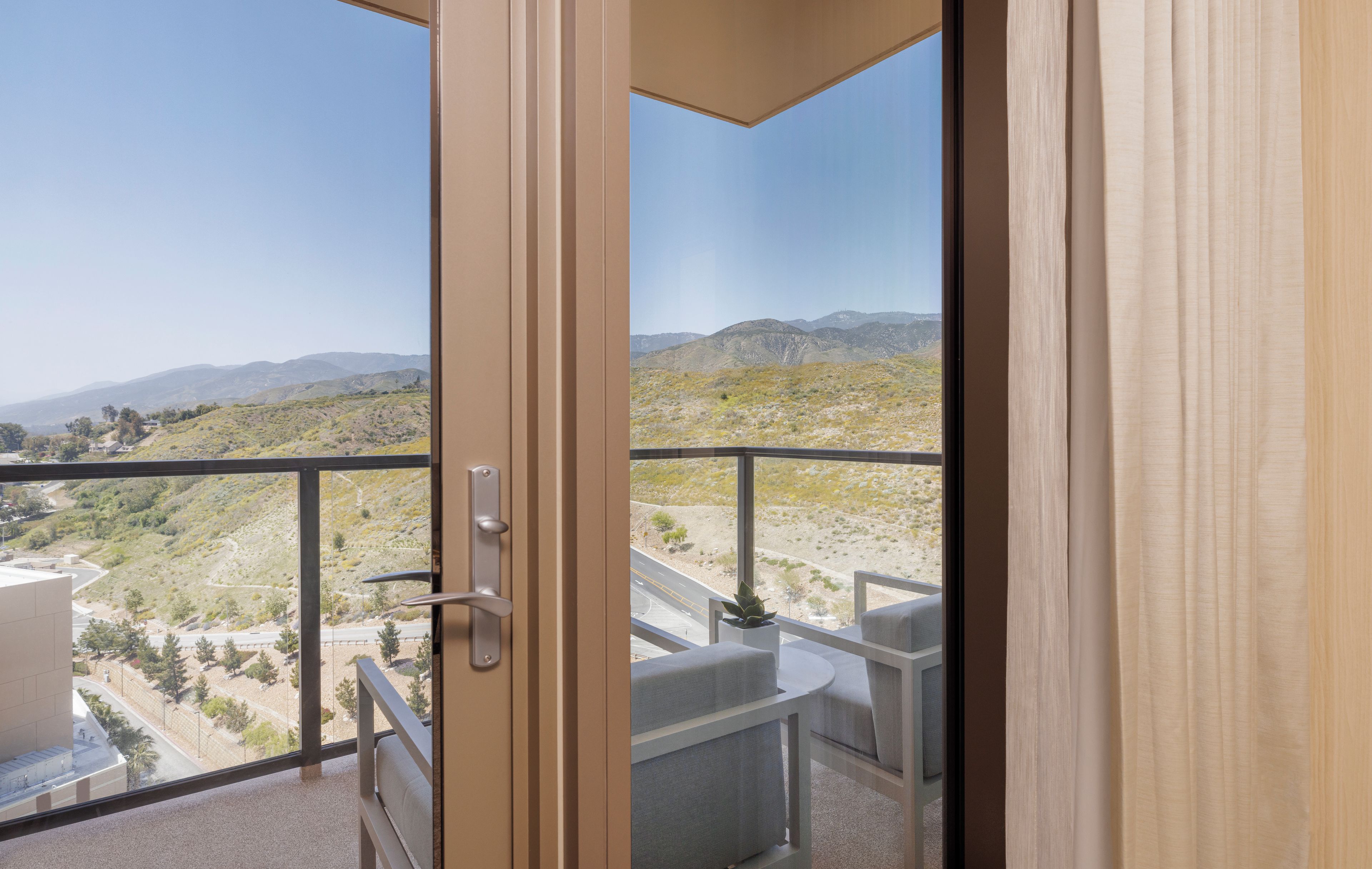 A balcony with a view of a hilly landscape.
