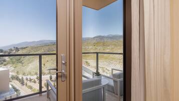 A balcony with a view of a hilly landscape.