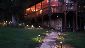 Un camino que lleva a un edificio de fachada de piedra y con un balcón.