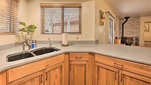 Eine Küche mit Holzausstattung, einem Spülbecken und einem Fenster mit Jalousien.