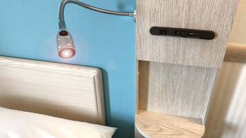 Una cama con cabecera de madera, una mesita de noche y un enchufe con puerto USB y puerto VGA.