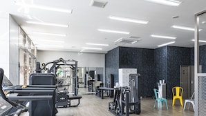 Un gimnasio moderno con cintas de correr, máquinas de pesas y pesas libres.