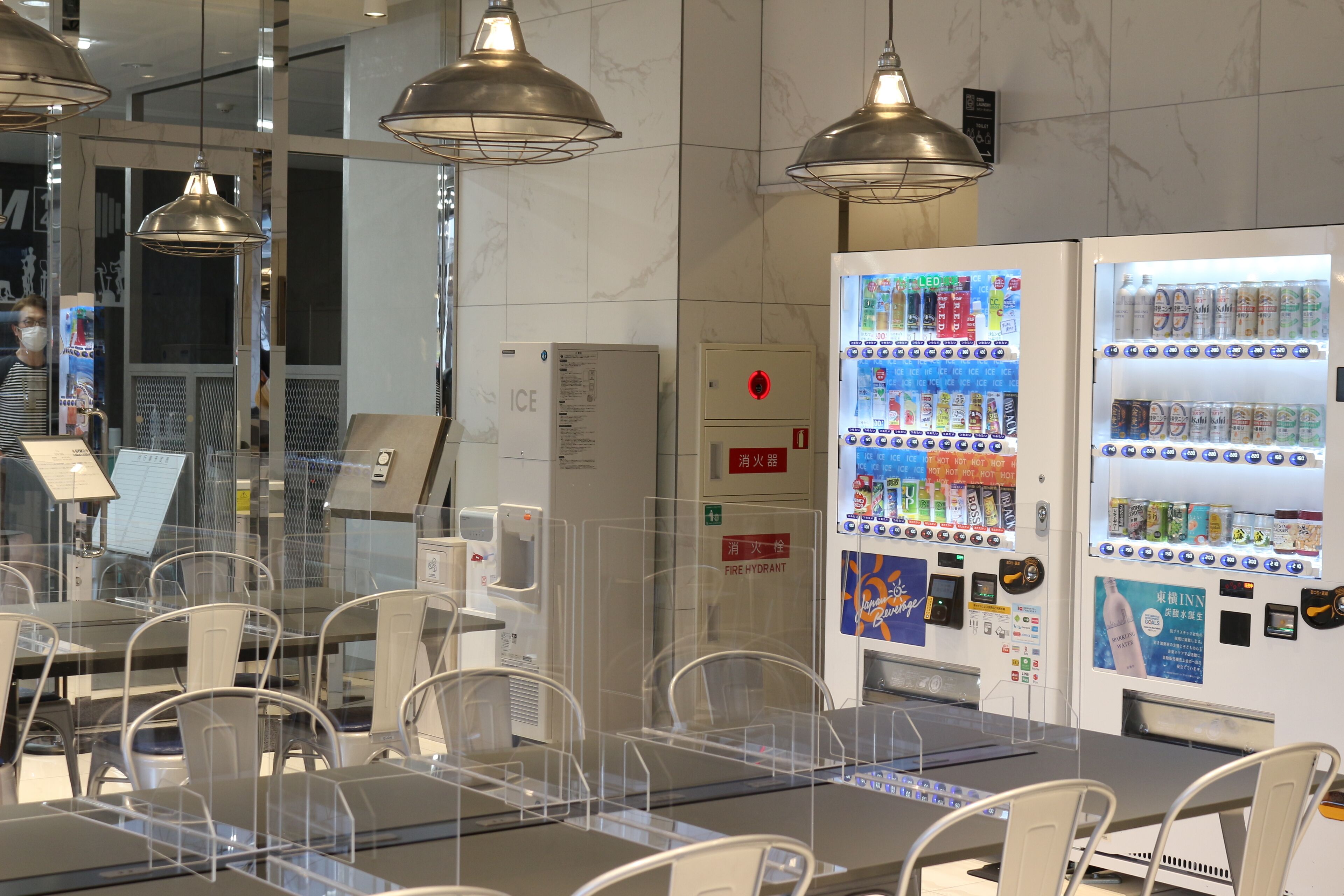 A restaurant with tables and chairs, vending machines, and a fire hydrant sign.