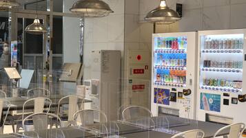 A restaurant with tables and chairs, vending machines, and a fire hydrant sign.