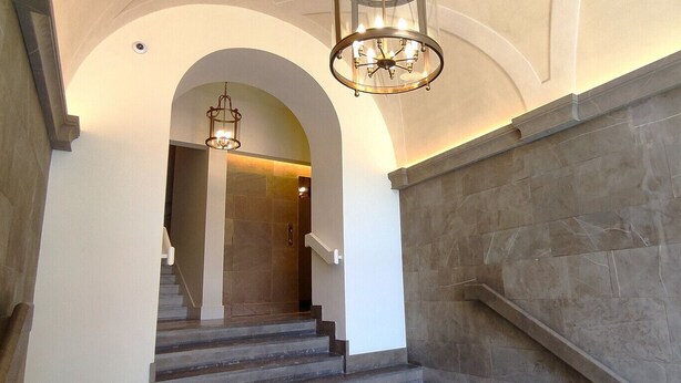 Eine prächtige Treppe mit Steinwänden und einer Chandelier.