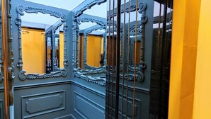 Un couloir orné de miroirs et doté d’un sol en marbre.