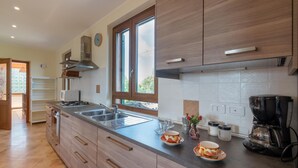 Eine moderne Küche mit einer großen Kochinsel, Edelstahlgeräten und Holzschränken.