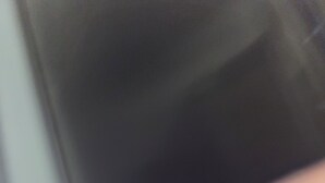 Ein Detailaufnahme einer dunklen, strukturierten Oberfläche, möglicherweise eine Wand oder ein Möbelstück.