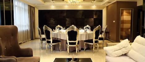 A luxurious dining room with a chandelier, a round table, and elegant chairs.