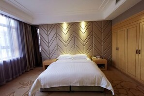 A hotel room with a large bed, wooden wardrobe, and a chevron-patterned wall. - Faguo Hotel (Dalian)