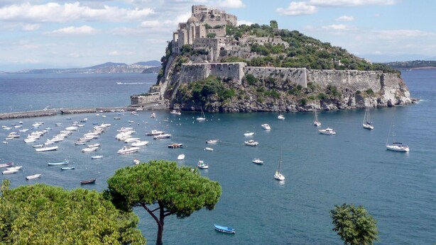 A coastal town with a historic castle on a hill, surrounded by a harbor with numerous boats. - Cozy apartment in Ischia with WiFi (Ischia)