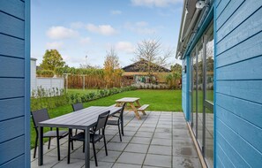 Enjoy a peaceful outdoor space with a picnic table, chairs, and lush garden.