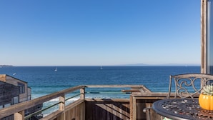 A wooden deck with a view of the ocean and sailboats. - Coastal Luxury: Oceanfront Views, Decks + Walkable to Downtown (Monterey)