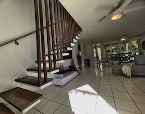 A modern interior with a staircase, a dining area, and a living room.