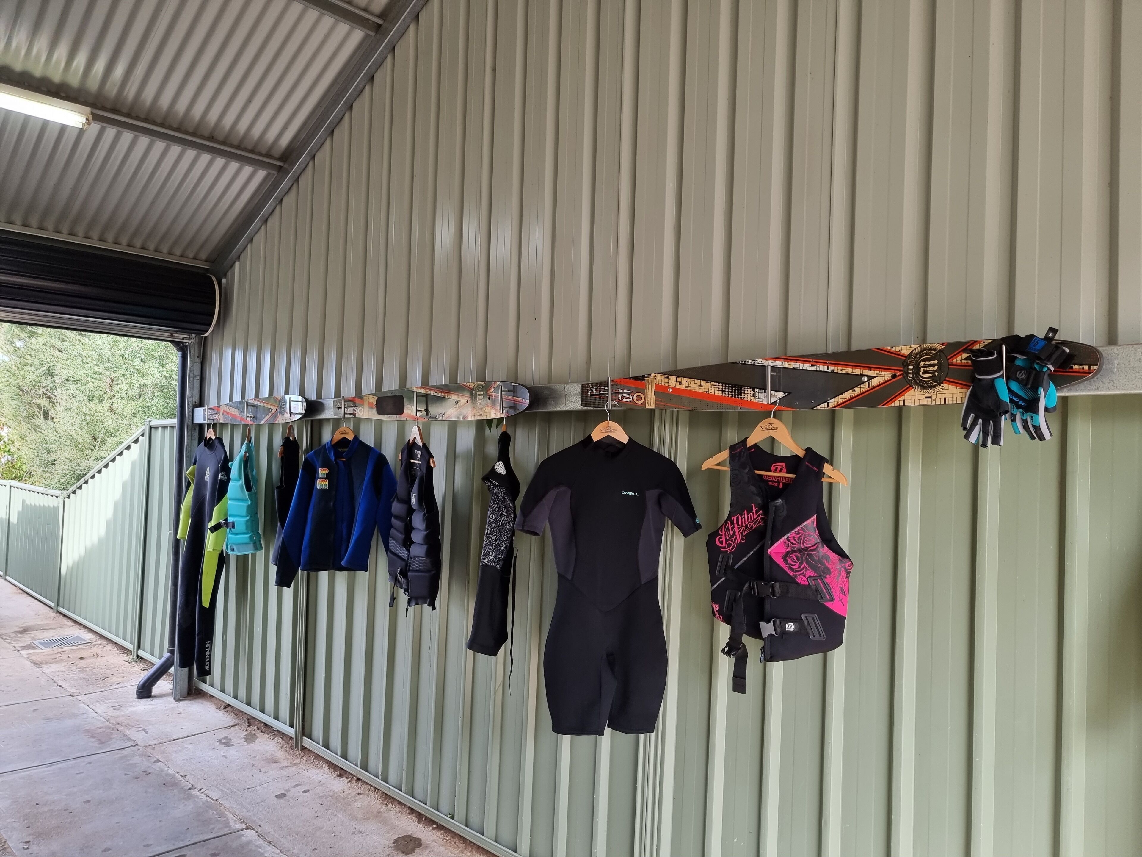 A wall with various sports gear and clothing items hanging.