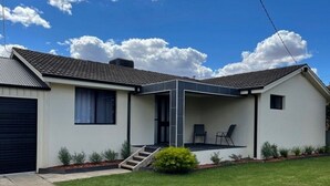 A modern single-story house with a covered patio, a garage, and a well-maintained lawn. - Aqua Vista  – Family friendly accommodation right in the heart of Yarrawonga. (Yarrawonga)