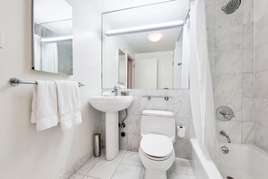 Un baño moderno con inodoro, lavamanos y bañera.
