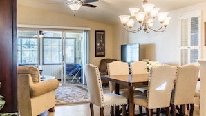 Un coin repas comprenant une table et des chaises, un ventilateur de plafond et un lustre.
