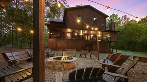 A rustic cabin with a fire pit, outdoor seating, and string lights. - Spacious 8 BR Broken Bow Family Cabin with Hot Tub, Fire Pit, Arcade, Swing (Broken Bow)
