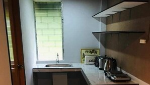 A compact kitchen with a sink, a window, and a countertop with a kettle and a coffee maker. - 1-Bed studio apartment in Kabankalan Philippines (Kabankalan, Negros Occidental)