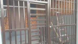 A metal gate with vertical bars and a ladder leaning against it. - 1-Bed studio apartment in Kabankalan Philippines (Kabankalan, Negros Occidental)