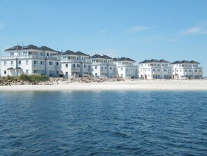 A beachfront hotel with multiple buildings, a sandy beach, and a calm sea.