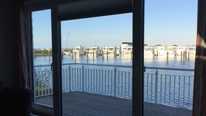 A room with a view of a water body, a balcony with a railing, and a chair. - Vacation Home "Lootsen Hus by Seeblick Ferien" with Sea View (OstseeResort Olpenitz/ Kappeln)