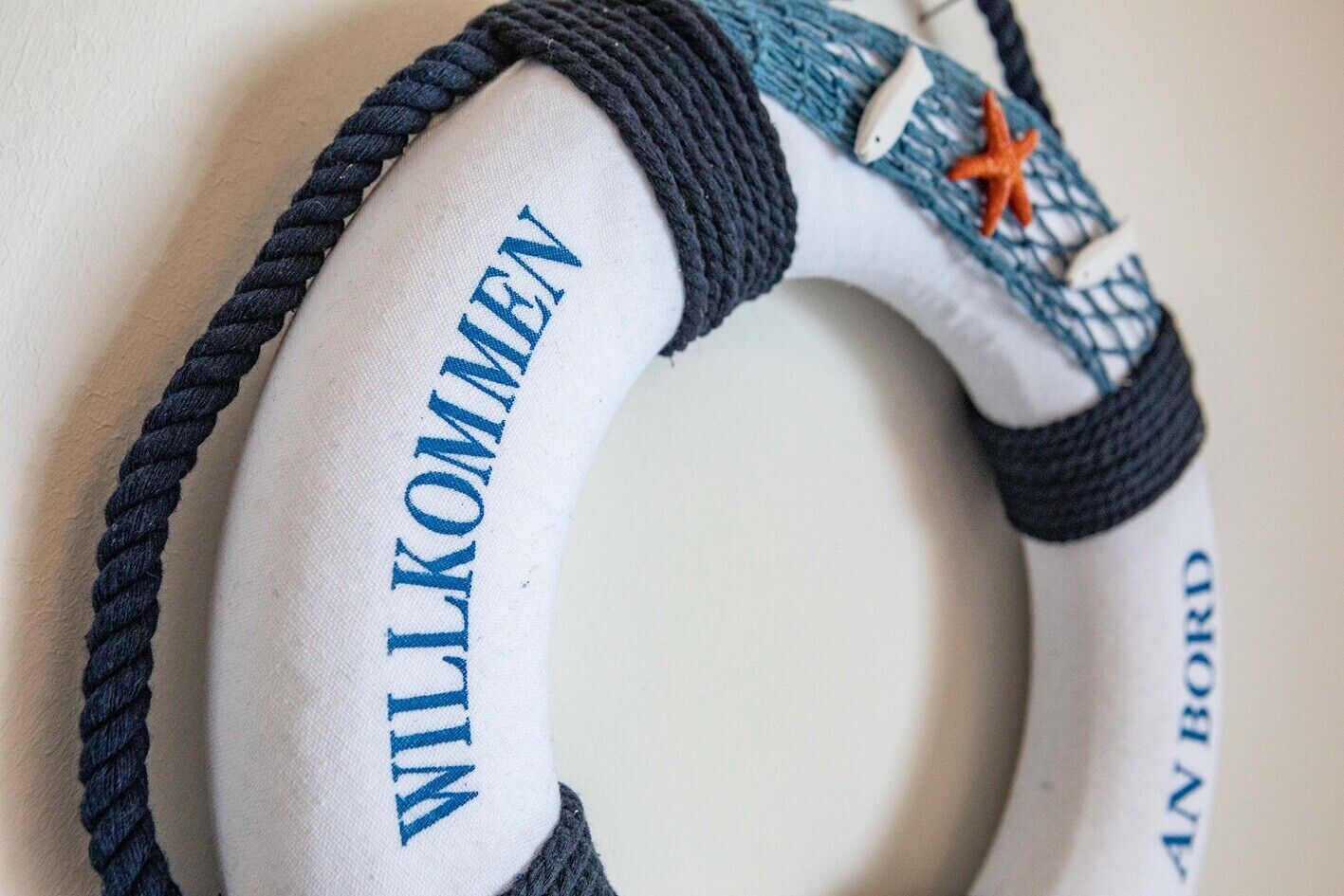 A lifebuoy with the text 'WILKOMMEN' and 'AN BORD' on it.