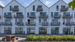 A modern multi-story building with balconies, large windows, and a clear sky. - Holiday Apartment "Reeders Nest by Seeblick Ferien" with Sea View (OstseeResort Olpenitz)