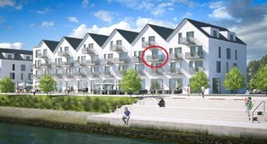 A modern building with multiple balconies, a waterfront view, and a pedestrian walkway. - Holiday Apartment "Reeders Nest by Seeblick Ferien" with Sea View (OstseeResort Olpenitz)