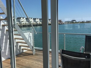 A view from a balcony overlooking a body of water with houses in the background.