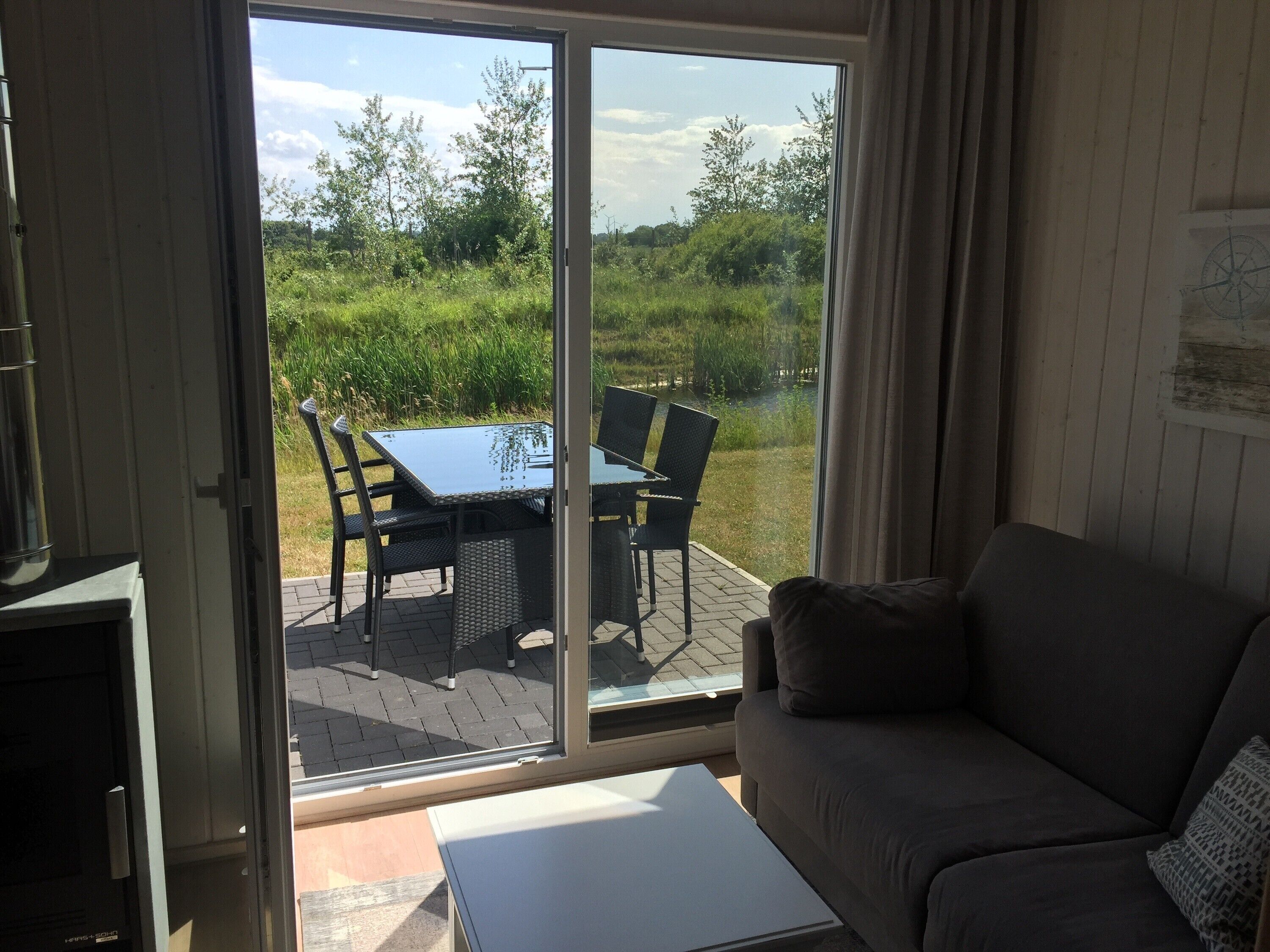 Une pièce dotée d’une porte-fenêtre coulissante donnant sur un patio extérieur avec une table et des chaises.