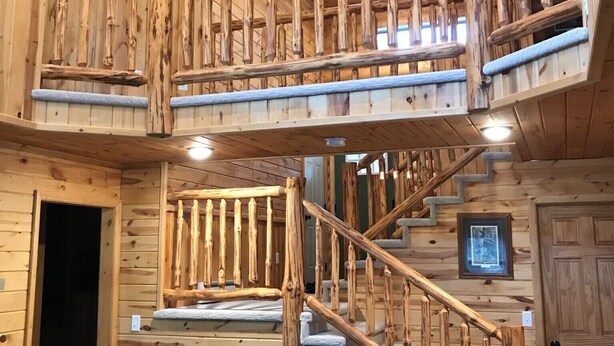 Un interior de madera con una escalera espiral, paredes de madera y una puerta.