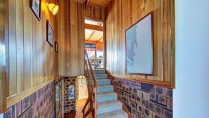 A wooden interior with a staircase, framed pictures, and a map on the wall. - Swan Cove (Coles Bay)